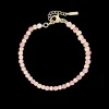 Goudkleurige armband met roze natuursteentjes