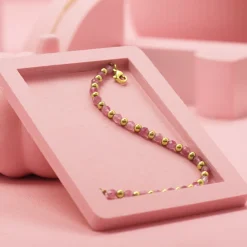 Goudkleurige armband met roze natuursteentjes