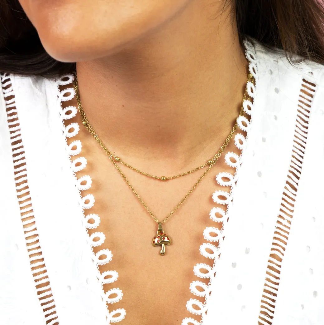 Goudkleurig/rode ketting met een paddenstoel bedeltje