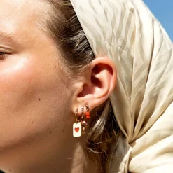 Rosé goudkleurige oorbellen met rode kraaltjes